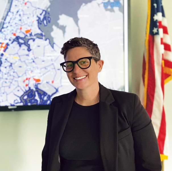 GIS Hero Hayley Gerkman smiles in front of a GIS map of New York City.