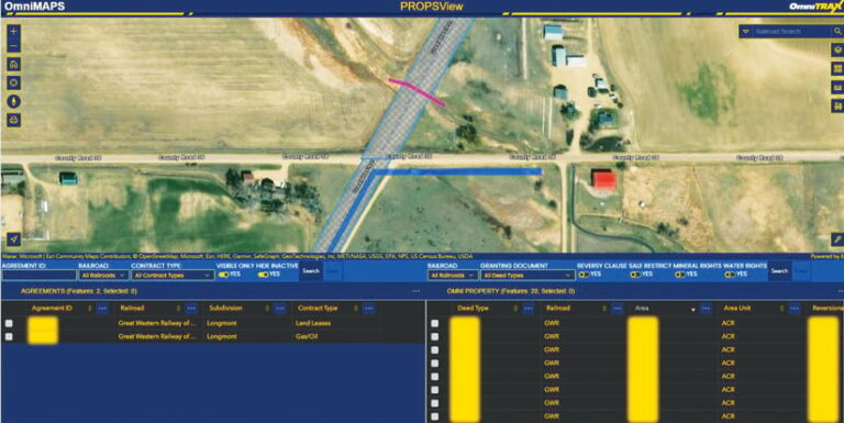 An OmniMAPS screenshot shows an overhead image of a mostly open, rural area with several structures and a few trees. A railroad section extends diagonally across the area, with added images that seem to show land lease and gas/oil contract types.