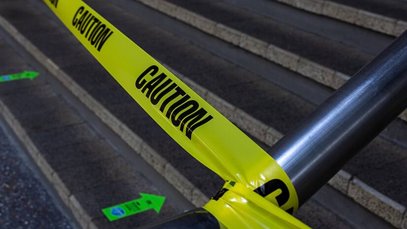 Caution tape on a railing suggests the need for risk management