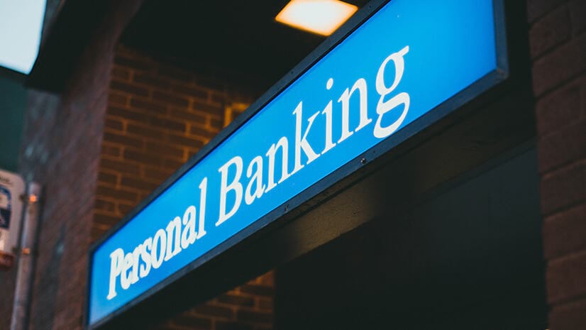 A sign for personal banking on a brick building