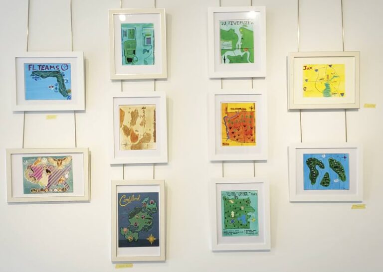 Ten framed pieces of map art hang on a wall.