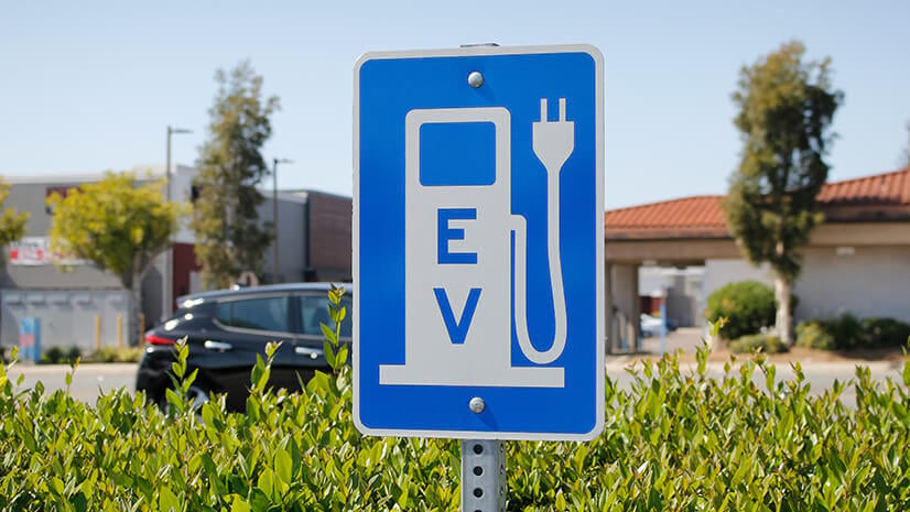 A road sign with an EV charger icon symbolizes EV infrastructure