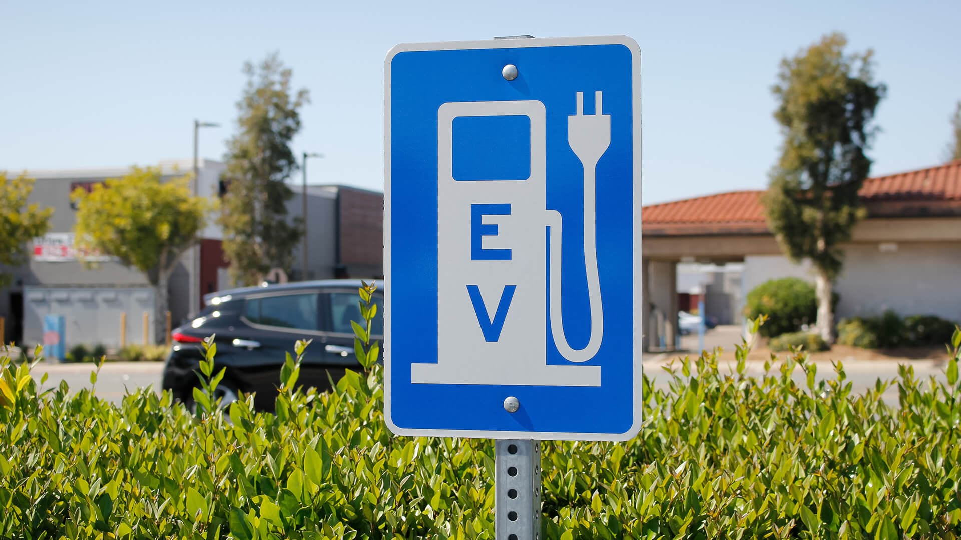 A road sign indicating an EV charger symbolizes EV infrastructure