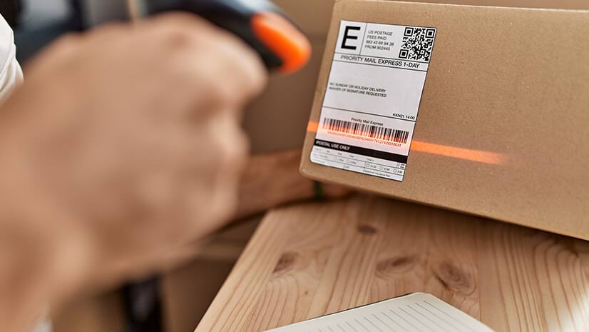 A package with a 2D barcode and UPC being scanned