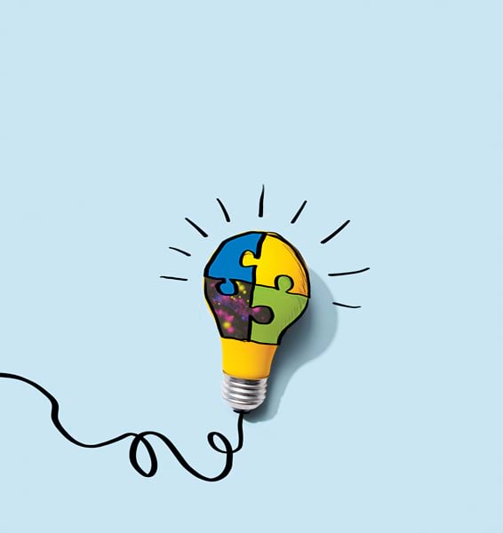A yellow lightbulb with a black cord has puzzle pieces drawn on it in blue, green, and yellow, illustrating the concept of problem solving. A yellow lightbulb with a black cord has puzzle pieces drawn on it in blue, green, and yellow, illustrating the concept of problem solving.