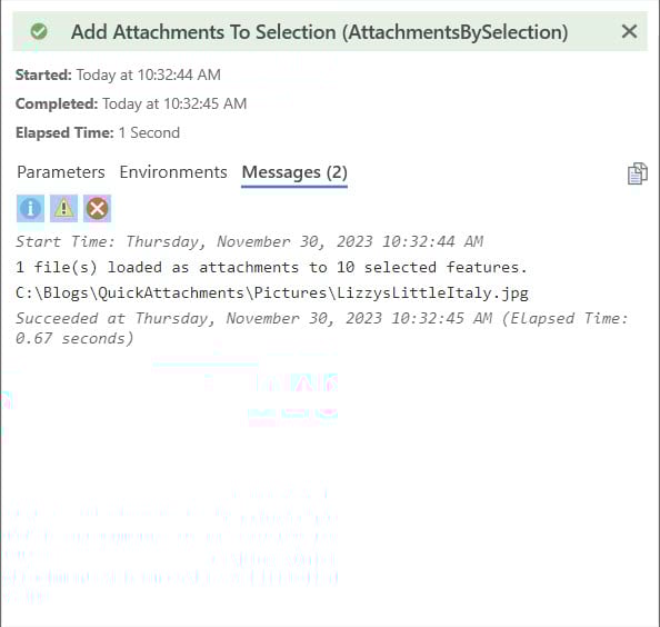 Dialog window with green banner showing a message of a successful process loading attachments to selected features.