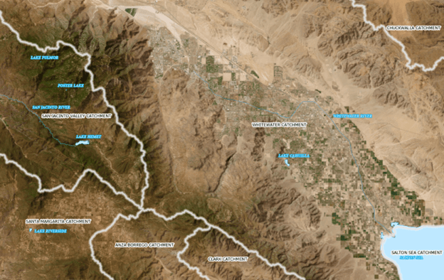 Aerial imagery of the desert showing with several polygons on it. There are blue polygons representing bodies of water and white, hollow polygons representing the extents of catchments.