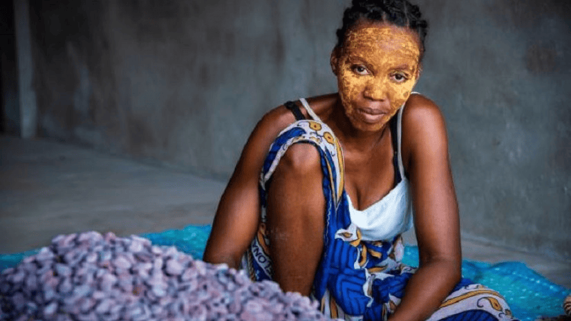 A person looks at the camera surrounded by flowers