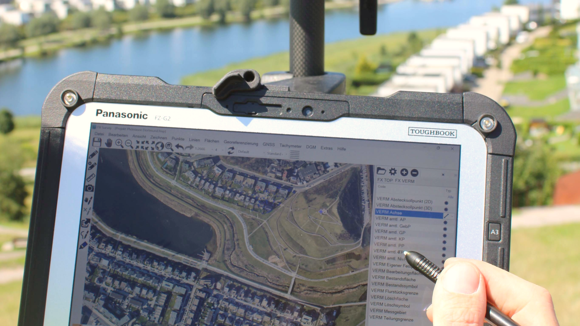 Close-up of a Panasonic Toughbook FZ-G2 tablet displaying a map, being used outdoors with a stylus.