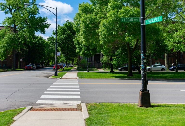 Sidewalk and curb ramp at street crossing.