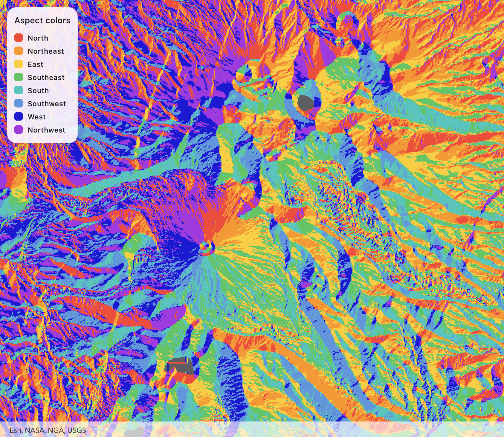 Aspect map of Tongariro National Park showing slope direction classified into eight compass directions. Red, orange, yellow, green, cyan, blue, dark blue, and purple colours represent different slope orientations across volcanic craters, ridges, and valleys.