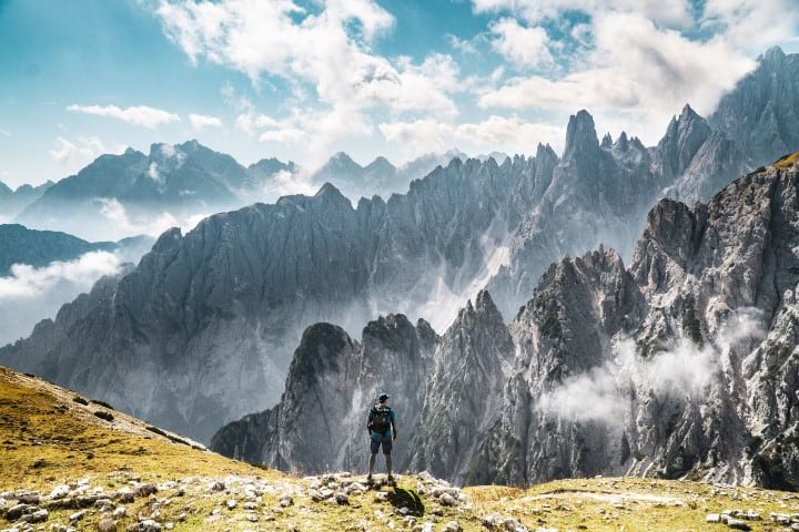 A hiker overlooks a rocky alpine vista in Italy.