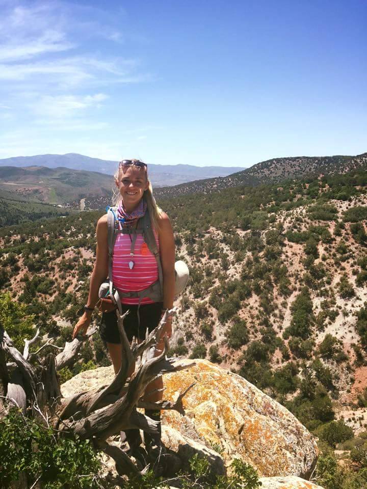 Amanda Huber poses for an outdoor picture as she hikes in the mountains.