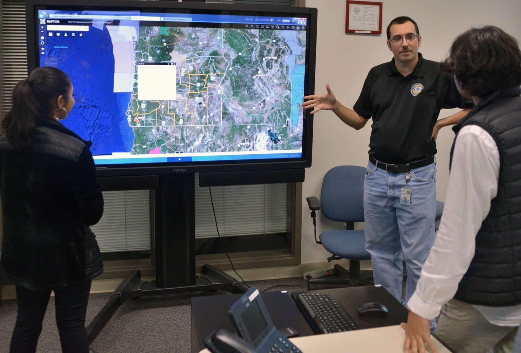 Daniel Stoelb, GIS program manager for Oregon's Office of Emergency Management, discusses the RAPTOR application with two students Daniel Stoelb, GIS program manager for Oregon's Office of Emergency Management, discusses the RAPTOR application with two students