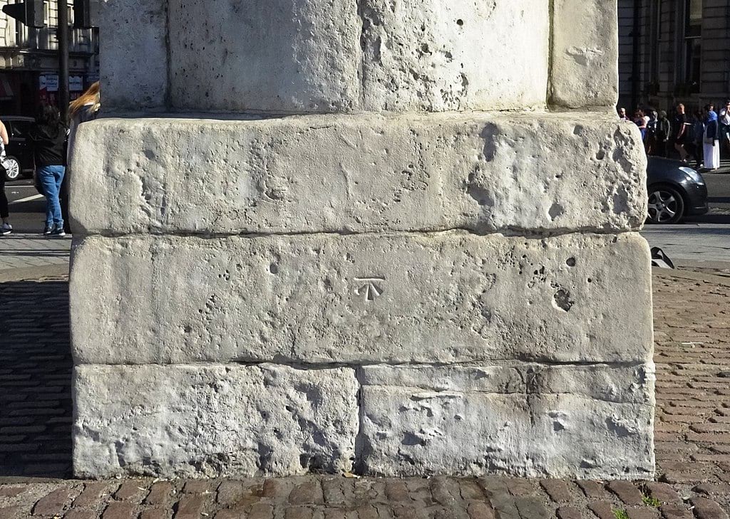 Ordnance Survey benchmark visible on the plinth of the statue of King Charles I in Trafalgar Square, London. This statue stands at the former location of the medieval Charing Cross, and marks the notional centre of London from which mileages are measured.