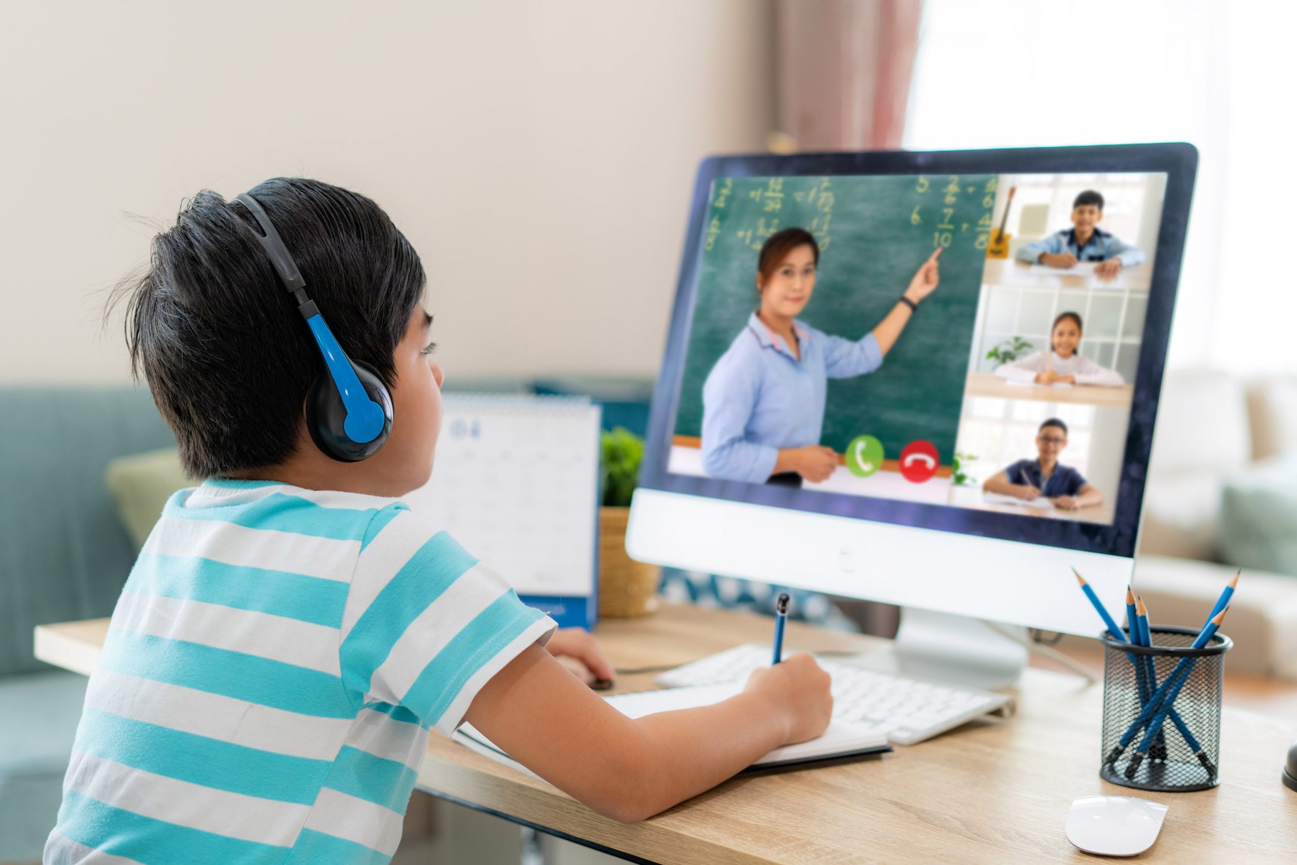 Elementary aged student attending school from home using a computer