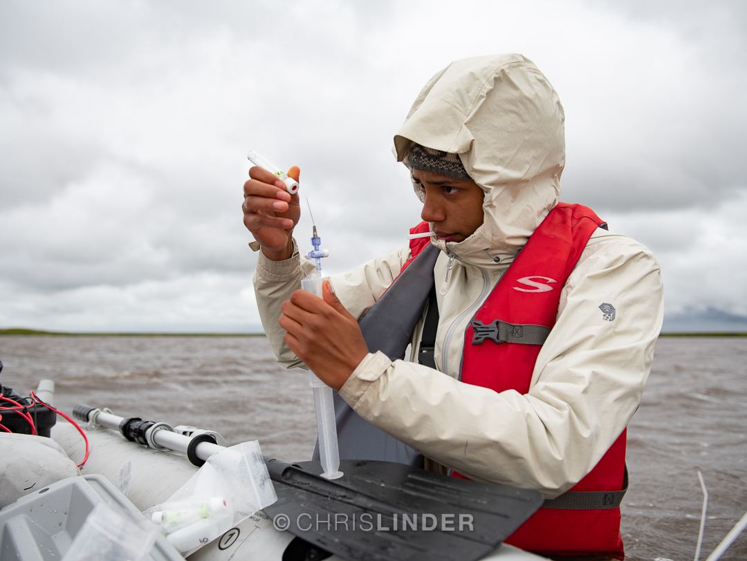 woman on a boat collects a water sample