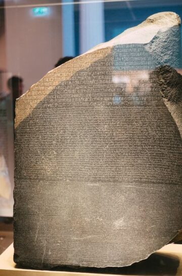 A stone tablet in a glass case inscribed with ancient writing