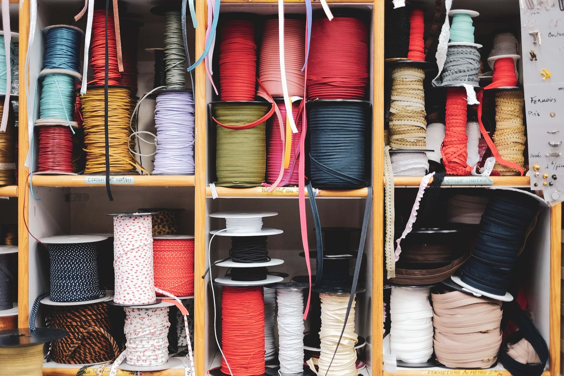 Multi-colored spools of thread sit in small divided cubbies