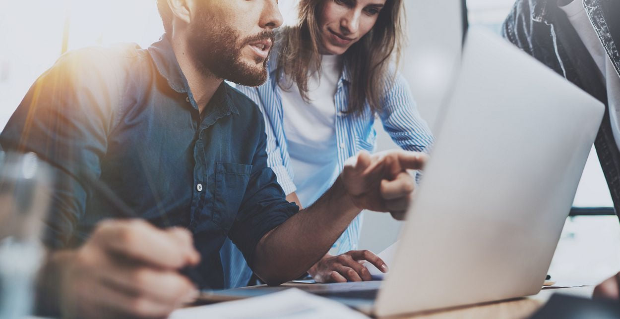 Two coworkers looking at laptop screen