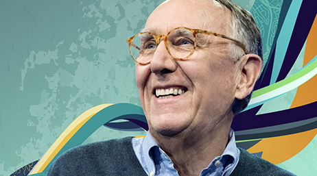Closeup photo of Jack Dangermond wearing a blue sweater and smiling as he looks away to the left, with an abstract swirling blue and orange background