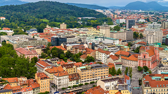 Buildings and roads in Ljubljana, Slovenia with rolling green hills in the background