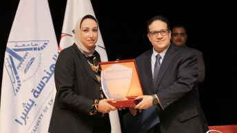 Two people dressed in business attire holding either side of an award for Egyptian Space Day