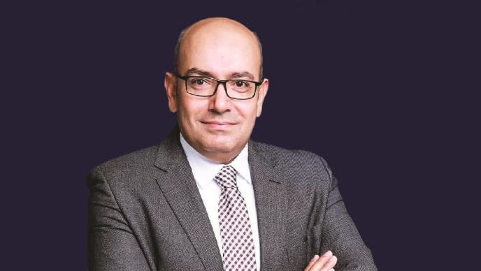 Sohail Elabd wearing business attire with his arms crossed against a dark background