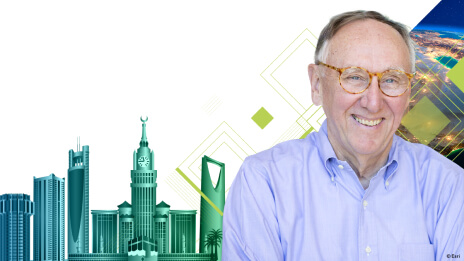 Photo of smiling Jack Dangermond in a pale purple shirt with an abstract graphic blue and green background of a stylized city skyline