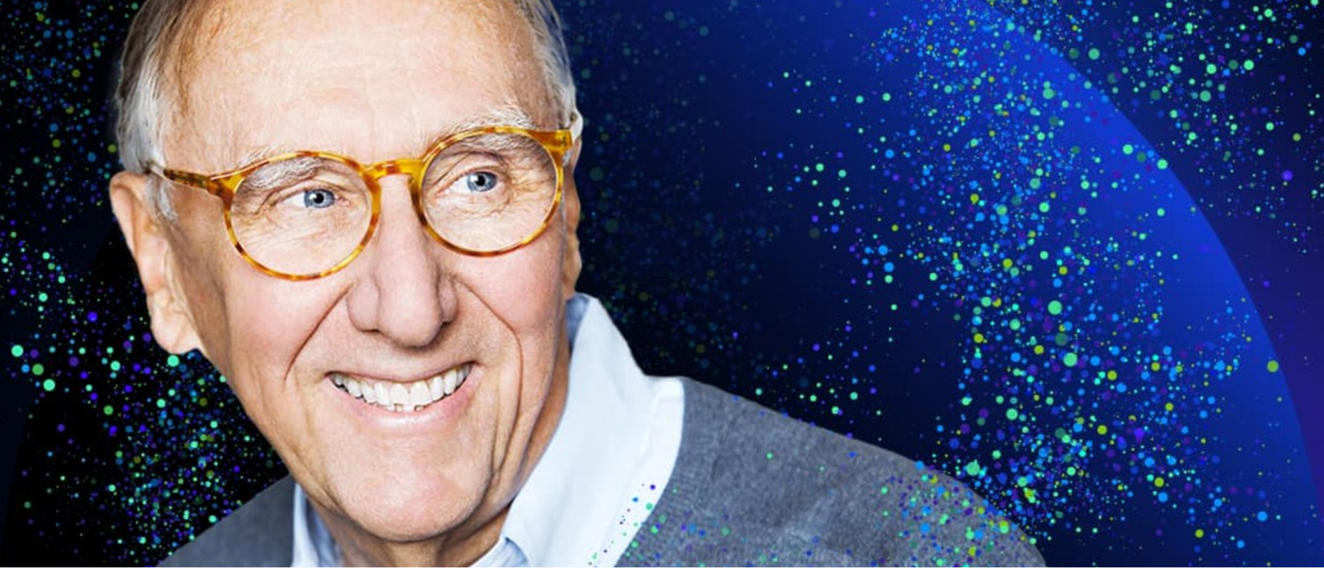 Esri Başkanı Jack Dangermond, gözlük takıyor ve mavi bir kazak giymiş; üzerinde bir oynat düğmesi yer alıyor.