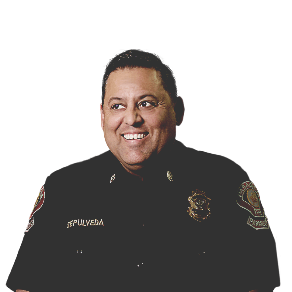 Oscar Sepúlveda, capitán de bomberos de la ciudad de Pasadena, vistiendo su uniforme y sonriendo, y un desfile de fondo