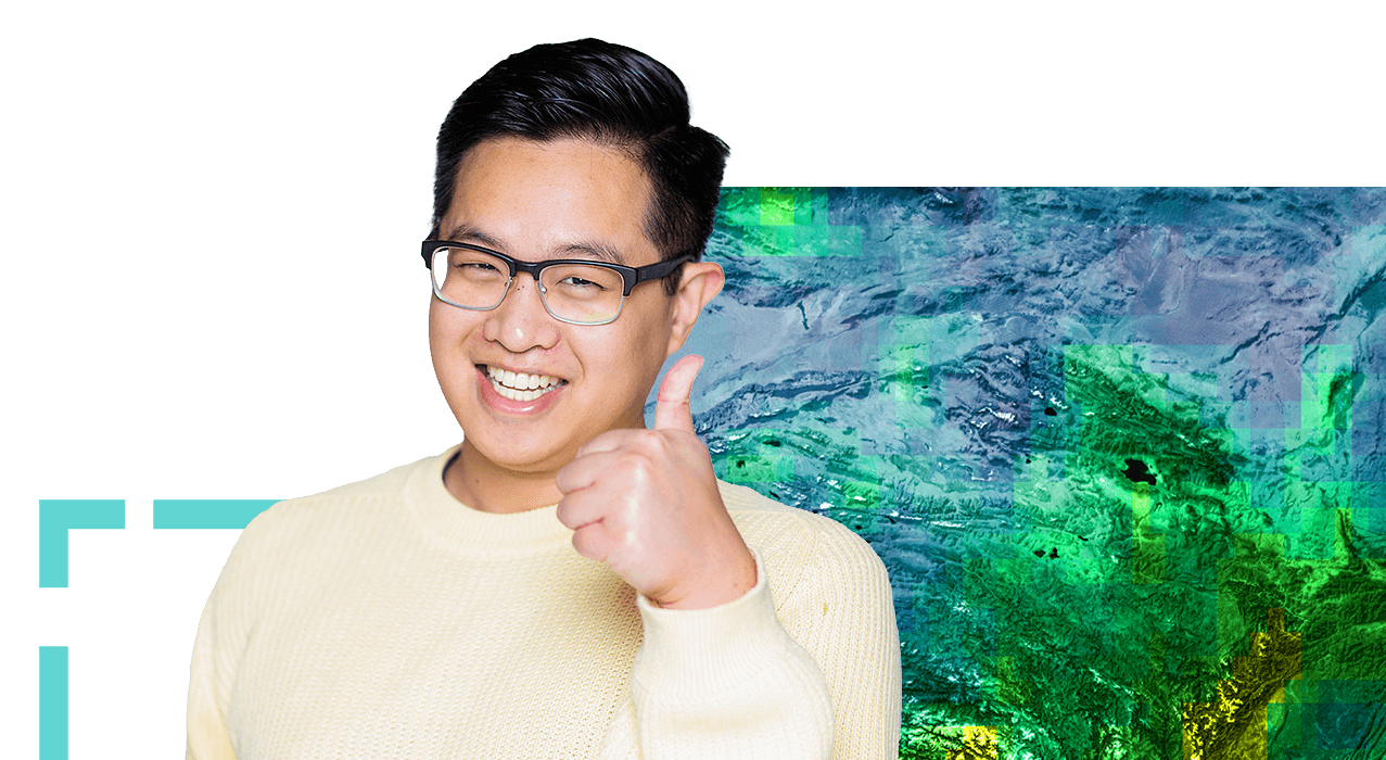 A smiling person in glasses and a cream sweater giving the camera a thumbs-up gesture against a background of a blue and green contour map