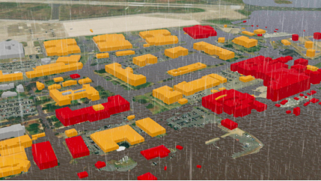A 3D model of a multi-building facility showing potential flood impacts, with at-risk buildings highlighted red and orange