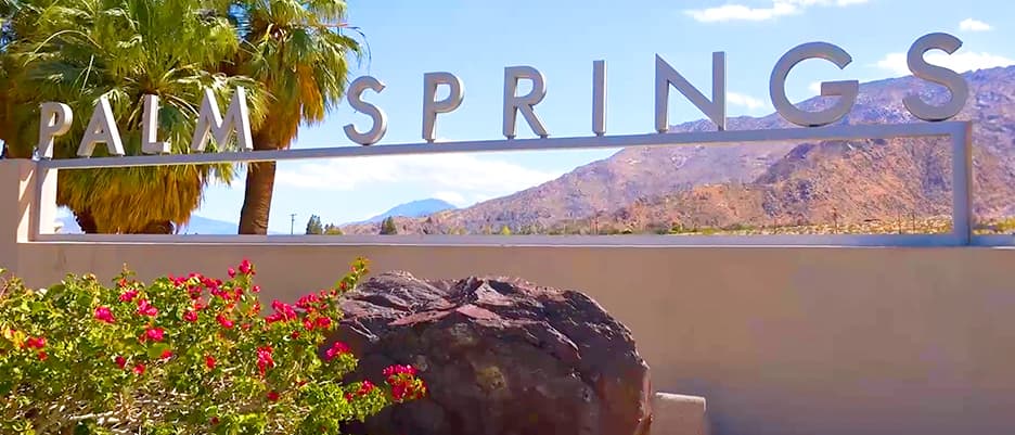 Aerial view of Palm Springs, California overlaid with a clickable play button to start the video