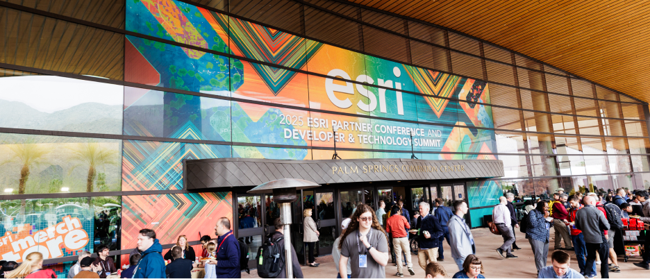 Video still showing event attendees gathered outside the Palm Springs Convention Center with a play button in the center