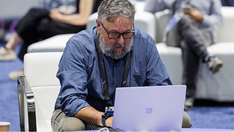 Person seated in a lounge chair focused on a laptop