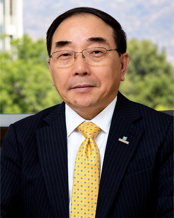 Portrait of Chancellor S. Jack Hu wearing a black suit jacket and yellow patterned tie.
