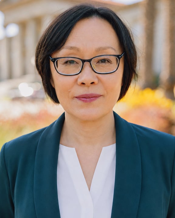 Professor Sawa Kurotani wearing glasses, a dark teal blazer, and white blouse