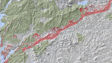 Terrain map in gray and green with a red area indicating a highway through the middle