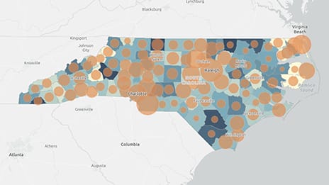 Map of the state of North Carolina, with differently-sized brown circles indicating high school dropout rates