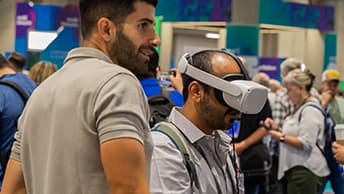 An attendee wearing a virtual reality headset as another person observes