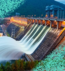 Illuminated hydroelectric dam releasing water through spillways
