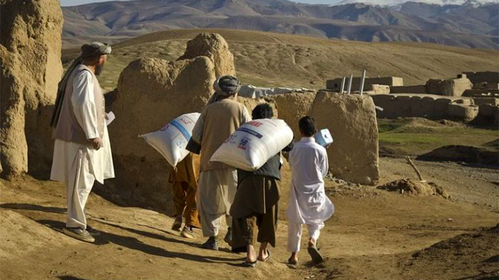 Villagers gather food rations in Afghanistan