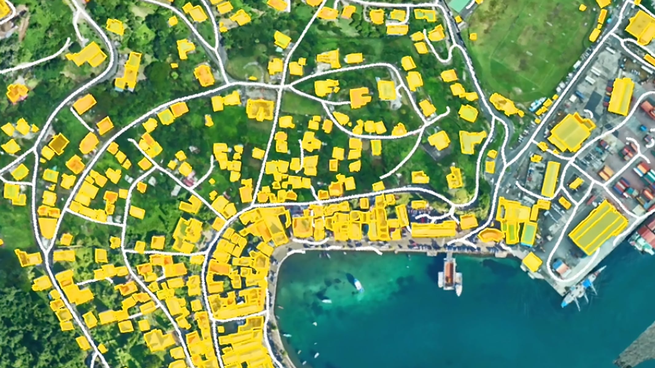 Veduta aerea di una città costiera con edifici e strade evidenziati in giallo brillante per la visibilità