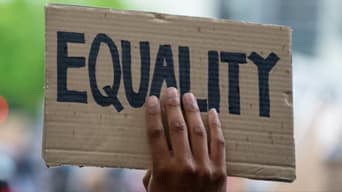 Image of a sign being held up that reads “Equality”