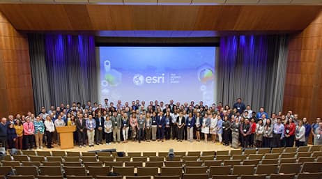 A group photo of conference attendees on a stage