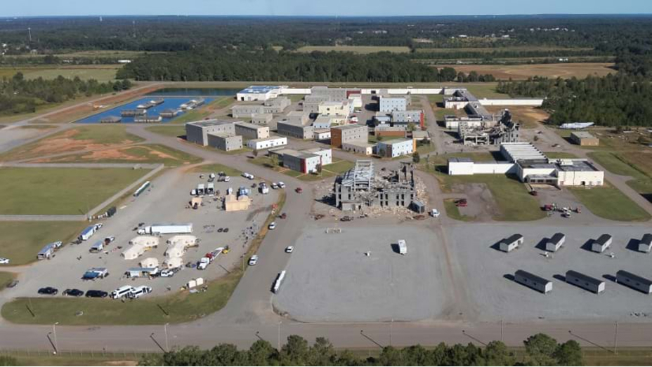 Aerial image of a sprawling compound against a backdrop of broad green fields and trees