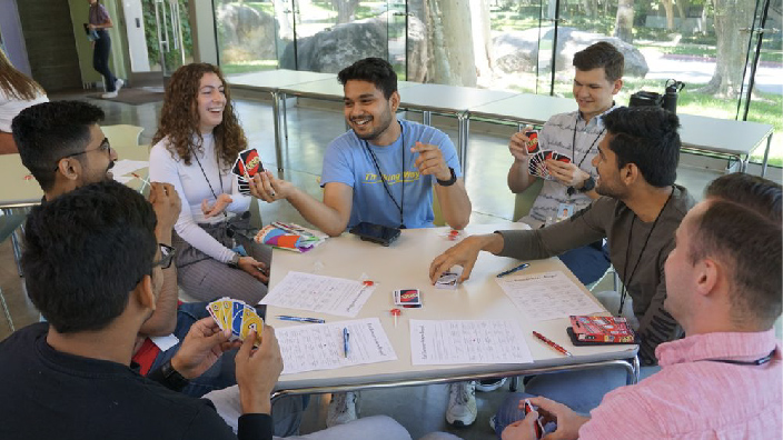 A group of young people sitting around a table playing a game