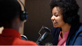 A person talking into a microphone for a podcast