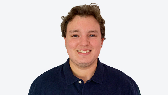 Portrait of Chase Cash smiling in a dark blue collared shirt